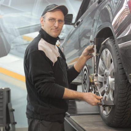 A man working on the tire of his car.